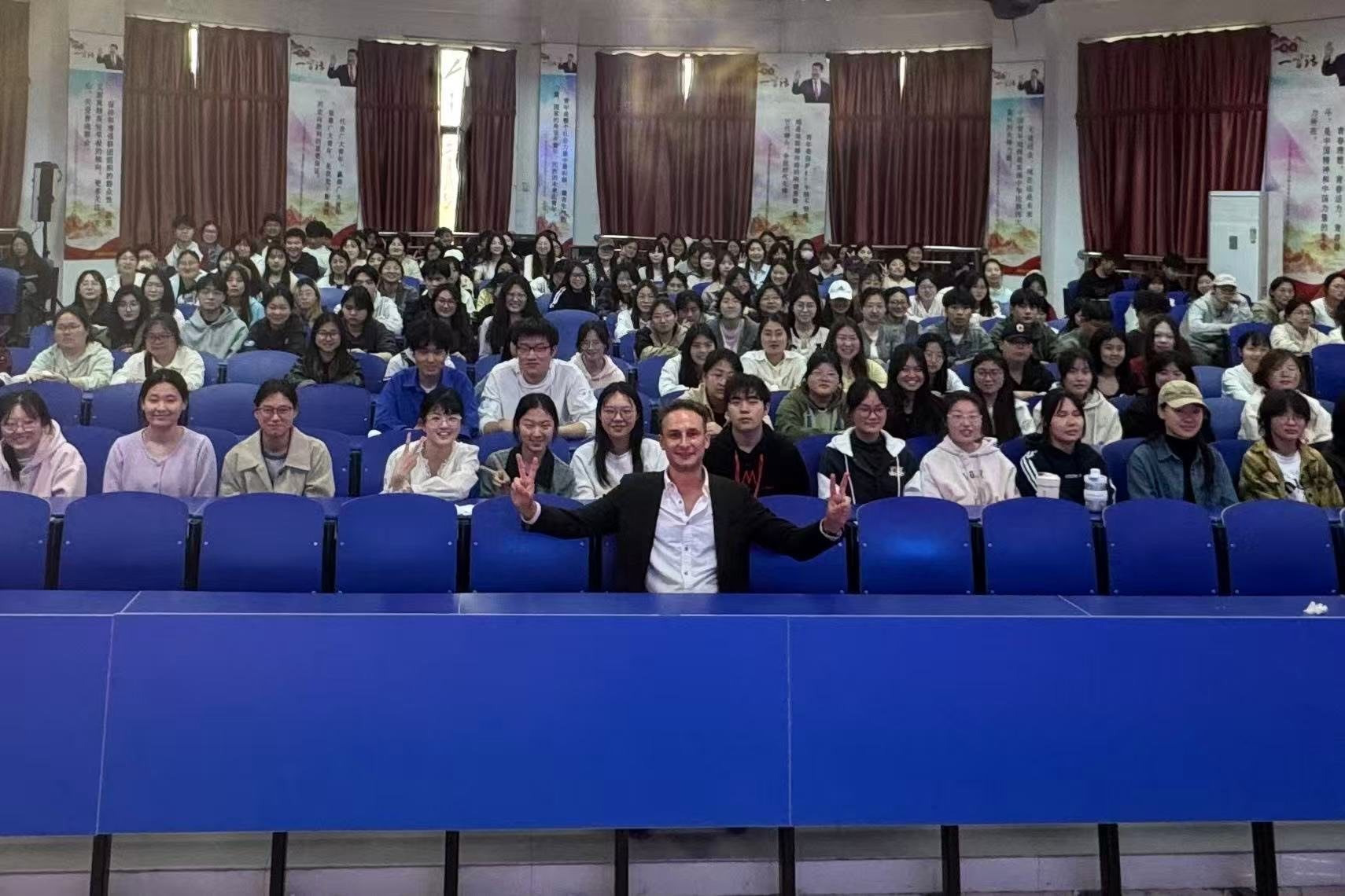 A visiting expert with students in a lecture hall at a partner university