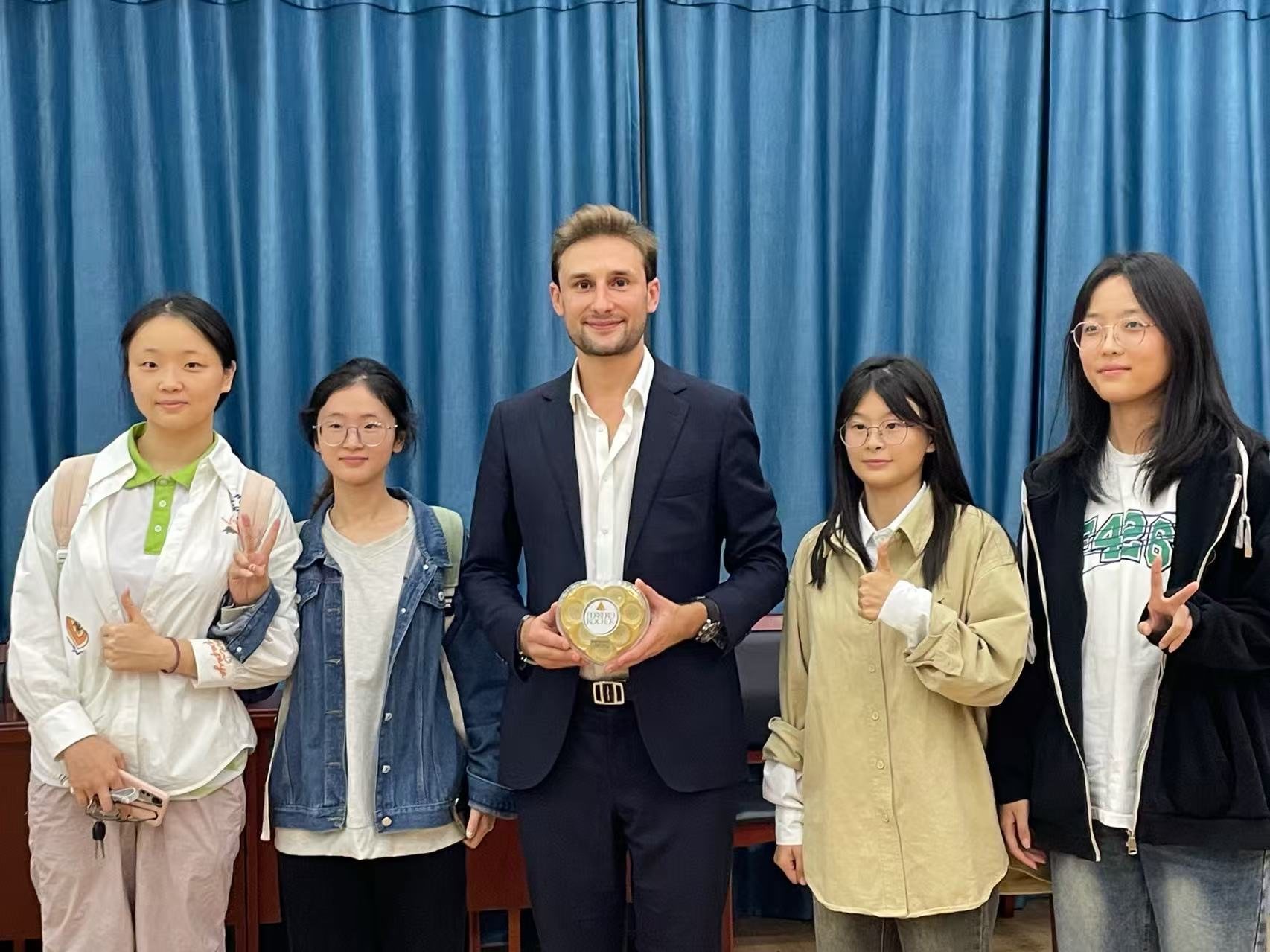 A visiting expert presented with a gift by students at a partner university
