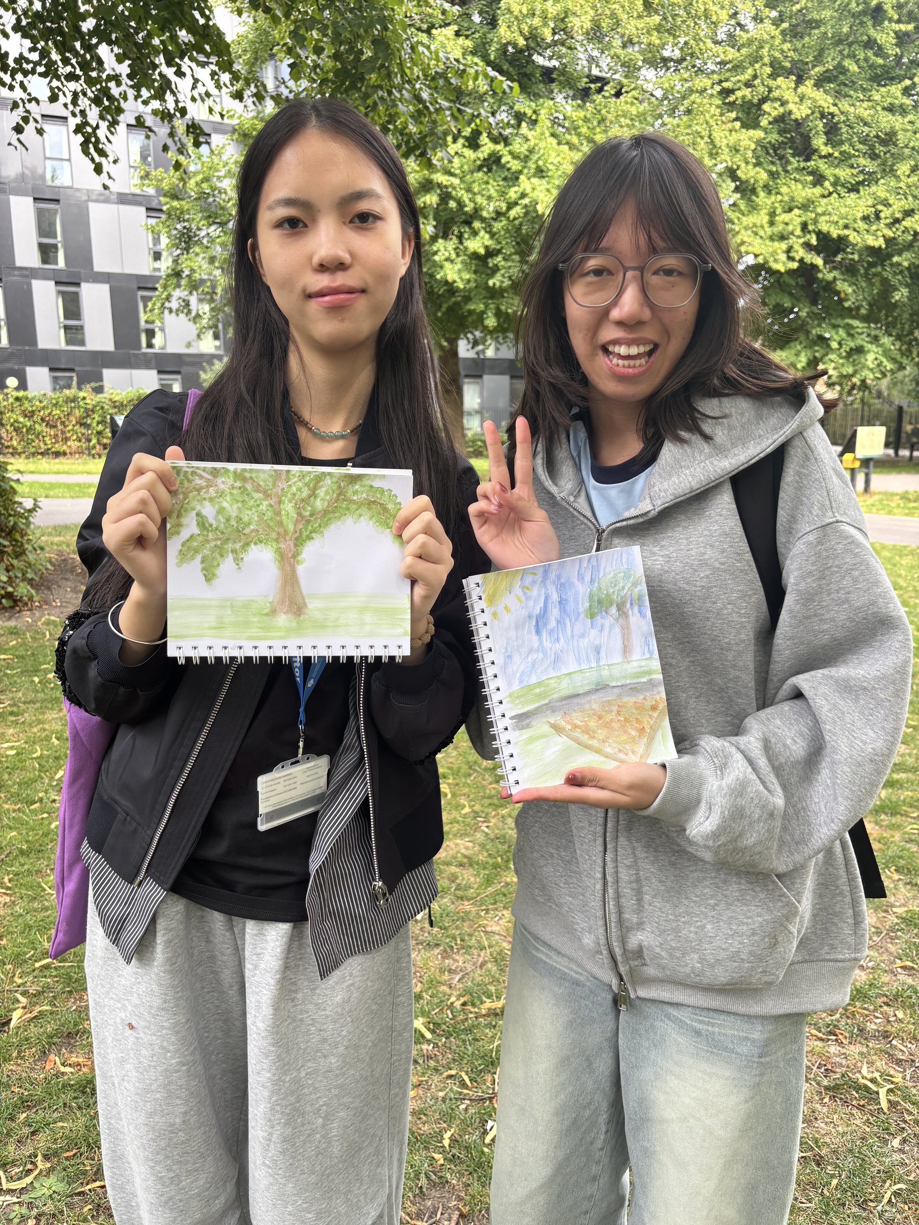 Chinese students showing watercolour paintings during a UK summer programme
